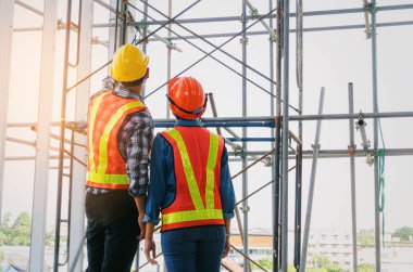 plan proje inşaat sitesi sanayi, endüstri kavramı içinde tebrik başlangıç için bina hakkında planlama mühendisi veya teknisyen erkek ve kadın tutarak mobil radyo kask ile bir kaç telefon