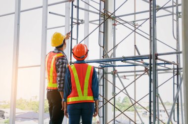 plan proje inşaat sitesi sanayi, endüstri kavramı içinde tebrik başlangıç için bina hakkında planlama mühendisi veya teknisyen erkek ve kadın tutarak mobil radyo kask ile bir kaç telefon