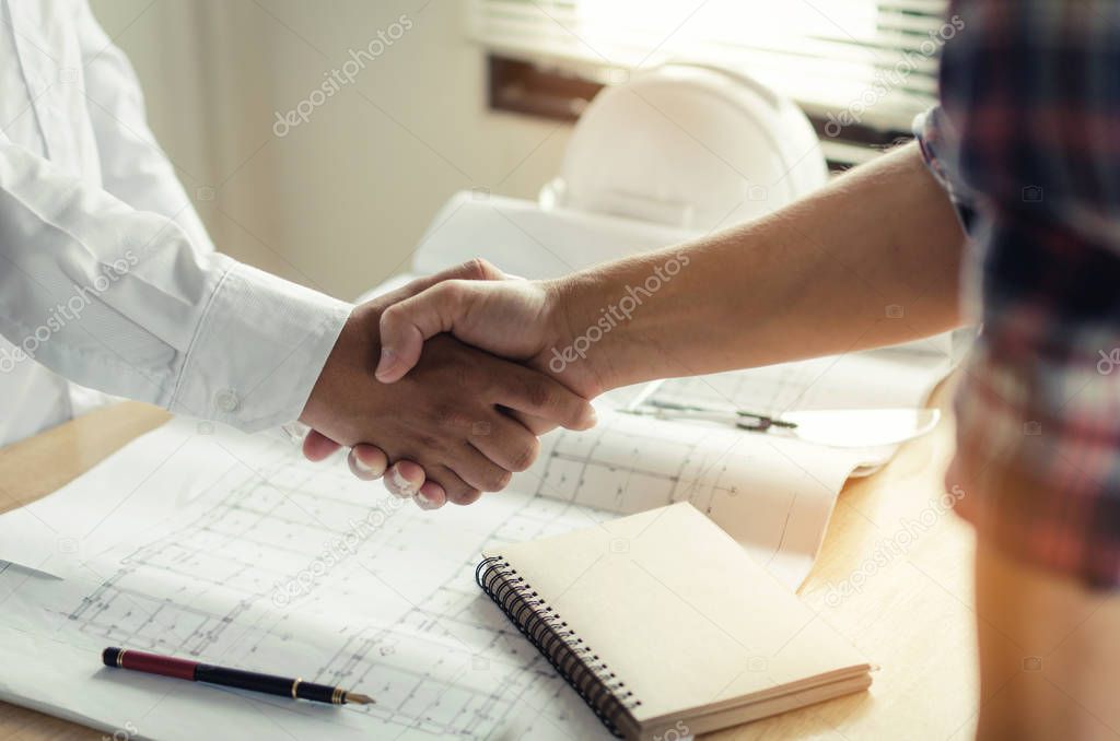 construction worker shaking hands with customer after finishing up business meeting to greeting start up project contract in office center at construction site, business and engineering concept