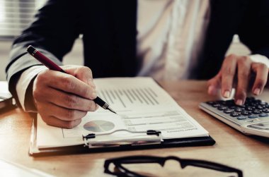 profesyonel yatırımcı veya iş adam analizi ve finansal raporlarda hesaplama ve Danışma ofisi, yatırım, mali müşavir, çalışma ve para kavramı kaydetme iş üzerinde hesap makinesi kullanma