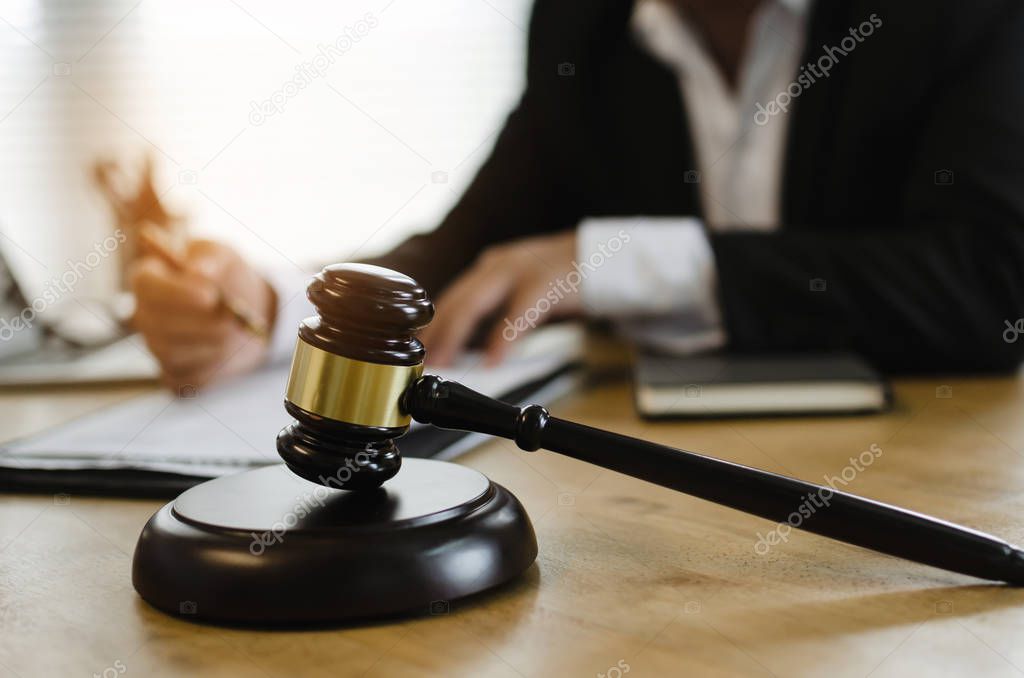 justice lawyer in black suit working about legal legislation with documents on workplace desk in courtroom office behind wooden judge gavel, occupation, business, justice law and legal service concept