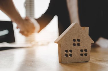 Ev modeli, yatırım, ev kredisi sözleşmesi, arkasında emlakçı ofisinde ev satın almak için sözleşme imzalama sonra Emlak broker Yöneticisi el sallamak için müşteri satın almak ve satmak ev kavramı