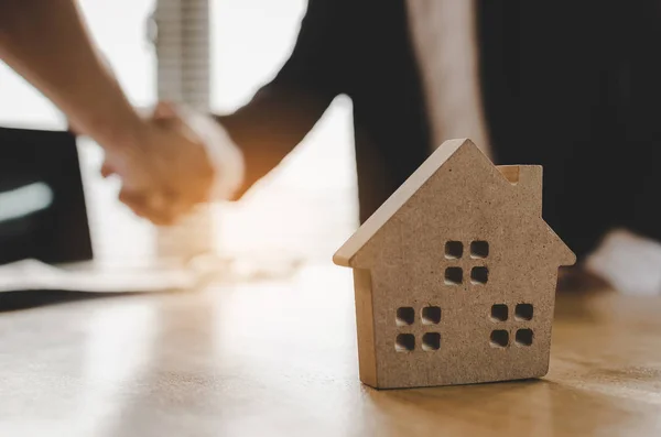 Ev modeli, yatırım, ev kredisi sözleşmesi, arkasında emlakçı ofisinde ev satın almak için sözleşme imzalama sonra Emlak broker Yöneticisi el sallamak için müşteri satın almak ve satmak ev kavramı