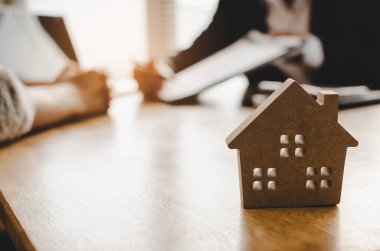 ev ev modeli, yatırım, ev kredisi sözleşmesi, gayrimenkul, sigorta, arkasında emlakçı ofisinde Emlak komisyoncusu ile satın almak için imza sözleşme müşteri satın almak ve satmak ev kavramı