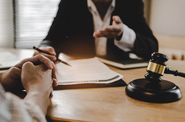 юридические консультанты, нотариус или юрист, обсуждающие договорные документы с ноутбуком деревянный судья молоток на столе в офисе суда, бизнес, право правосудия, страхование и юридическое обслуживание концепции
