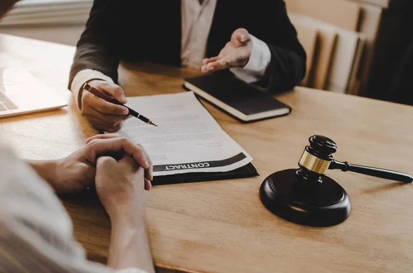 legal consultants, notary or justice lawyer discussing contract document with customer and wooden judge gavel on desk in courtroom office, business, justice law, insurance and legal service concept