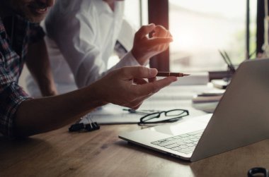 professional team of architect pointing with pen on laptop computer, blueprint and color palette on desk during discussing planing for new project at construction site, contractor, engineering concept