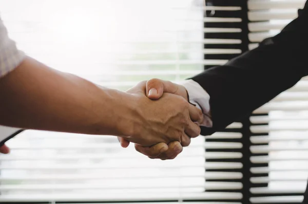 Deal - close up hand of two business people shaking hands after successful  job interview in modern meeting room at office, home loan contract, partnership, teamwork and business contract concept