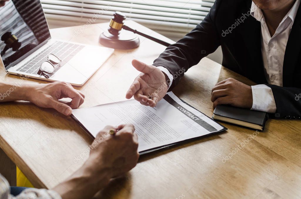 client customer signing contract and discussing business with legal consultants, notary or justice lawyer with laptop computer and wooden judge gavel on desk in courtroom office, legal service concept