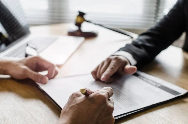 sözleşme imzalama ve mahkeme ofis, yasal hizmet kavramı masa üzerinde yasal danışmanlar, dizüstü bilgisayar ve ahşap Yargıç tokmak ile noter veya adalet avukat ile iş tartışırken istemci müşteri