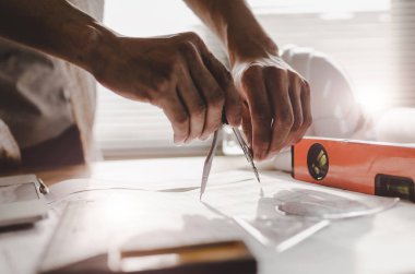 el profesyonel mimar, mühendis veya iç çizim planı ile İşyeri masa ofis merkezi inşaat alanında, yüklenici, inşaat, mühendislik ve iş kavramı üzerinde eller