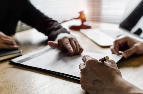 sözleşme imzalama ve mahkeme ofis, yasal hizmet kavramı masa üzerinde yasal danışmanlar, dizüstü bilgisayar ve ahşap Yargıç tokmak ile noter veya adalet avukat ile iş tartışırken istemci müşteri
