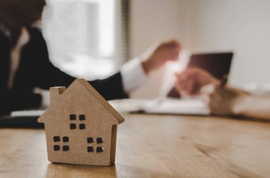 Emlak broker Yöneticisi veren anahtarları arkasında ev modeli, yatırım, ev kredisi sözleşmesi, Emlak, emlakçı ofisinde ev satın almak için sözleşme imzalama sonra müşteriye al, ev kavramı Sat