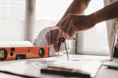 el profesyonel mimar, mühendis veya iç çizim planı ile İşyeri masa ofis merkezi inşaat alanında, yüklenici, inşaat, mühendislik ve iş kavramı üzerinde eller