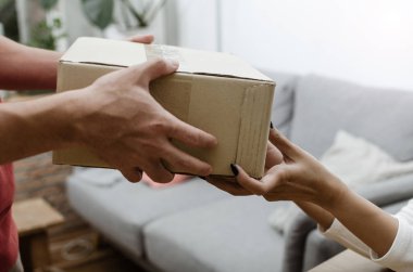 eve teslim hizmet adamın alıcı ve genç müşteri kurye evde parsel posta kutusundan kabul parsel kutuları teslim üniformalı elini yukarıya kapatmak, hızlı teslimat ve online alışveriş kavramı