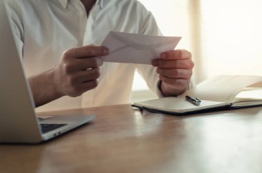 iş, iş konseptinden ateş kaybetme ofis, istifa mektubu, maaş veya promosyon yeni konumda, artan para bonus kart kağıt zarfın içinde tutan mutlu genç çalışan iş adamı