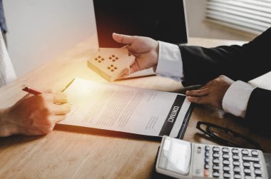 ahşap ev modeli emlakçı office, yatırım, ev kredisi sözleşmesi, ev satın almak için sözleşmenin imzalanmasından sonra müşteriye vererek Emlak broker Yöneticisi kavramı, ev ve Emlak satış