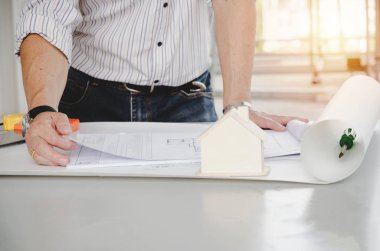 profesyonel mimar, mühendis veya plan ev modeli ve araçları office Merkezi inşaat alanında, yüklenici, kavram mühendislik inşaat, işyeri masasında iç kontrol