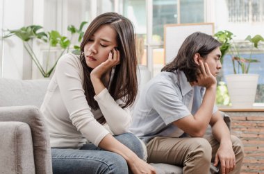 kavga sahip ve oturan kanepede birlikte, dövüşten sonra onun içinde ev iç arkasında kocası ile üzüntü genç Asya karısı üzgün çift, aşk, boşanma çift, Aile sorunları ve ilişki kavramı