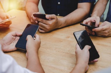 ev ofisinde masada oturan sosyal ağ oynarken akıllı telefon kullanarak arkadaş veya genç eller grup, dijital teknoloji, Wifi internet, ağ bağlantısı ve ilişki kavramı