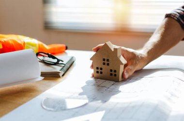 İnşaat, müteahhit, inşaat, mühendislik, ev tasarım konsepti ofis merkezinde işyeri masasında ev modeli ve planı ile profesyonel mimar, mühendis veya iç el