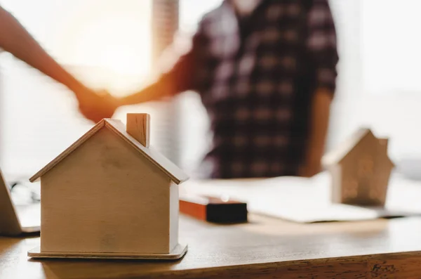 Ortaklık. İşyeri masasında ahşap ev modeli inşaat işçisi takım elleri ile iş ofisi ve müteahhit kavramı ofis merkezinde yeni proje sözleşmesi