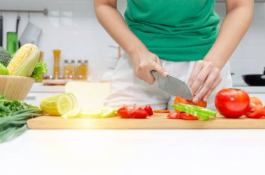Diyet. Yeşil gömlek kesme pişirme ve bıçak genç güzel kadın mutfakta iyi sağlıklı için taze sebze salatası hazırlamak evde, sağlıklı yaşam, yemek pişirme, sağlıklı gıda ve diyet kavramı