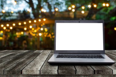 bahçede gece festivali gece ışığı bokeh ile masada beyaz boş ekran ile dizüstü bilgisayar bilgisayar, reklam, çalışma alanı, internet teknolojisi, online sosyal medya, arama veri kavramı