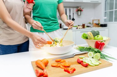 Diyet. yeşil ve kahverengi gömlek iki genç güzel kadın evde modern mutfakta iyi sağlıklı için kase de sebze salatası hazırlanıyor, sağlıklı yaşam tarzı, yemek pişirme, sağlıklı gıda ve diyet kavramı