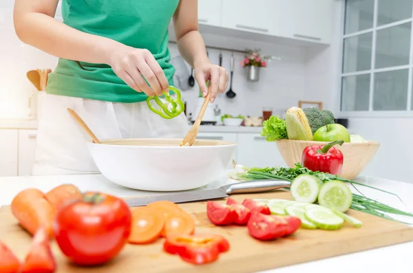 Diyet. Yeşil gömlek ayakta genç güzel kadın ve ev, sağlıklı yaşam, yemek, sağlıklı gıda ve diyet konsepti modern mutfakta iyi sağlıklı için kase sebze salatası hazırlanıyor