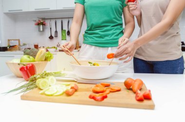 Diyet. yeşil ve kahverengi gömlek iki genç güzel kadın evde modern mutfakta iyi sağlıklı için kase de sebze salatası hazırlanıyor, sağlıklı yaşam tarzı, yemek pişirme, sağlıklı gıda ve diyet kavramı