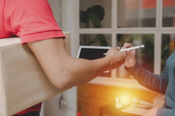 在数码移动平板电脑收件箱 快递和网上购物的概念中 女顾客可以从家里的快递员那里获得一张笔状递送服务人员的红衣签名 — 图库照片