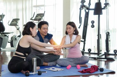 genç spor insanlar takım hedeflerine ulaşmak için planlama ve fitness salonu, egzersiz, eğitim, egzersiz, ortaklık, başarı ve takım çalışması kavramı yoga minderinüzerinde oturan birlikte el ele verme yapıyor