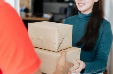mutlu genç asya kadın müşteri gülümseyerek evde ev teslim hizmeti adam dan parsel posta kutusu almak, ekspres ev teslim hizmeti, kargo nakliye, ulaşım lojistik ve online alışveriş konsepti