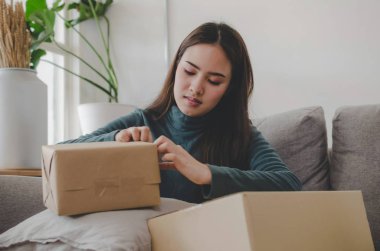 Kobİ başlangıç. asya genç girişimci kadın çalışma ve ambalaj karton koli kutusu için ev ofis, alışveriş online, küçük işletme sahibi, lojistik ve teslimat kavramı müşteriye sipariş göndermek için