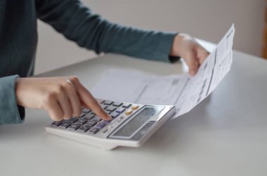 analiz ve hesap makinesi kullanarak genç kadın ev ofis masada aile bütçesi maliyet faturaları raporu, plan para maliyet tasarrufu, yatırım, iş finansmanı, giderleri ve gelir kavramı