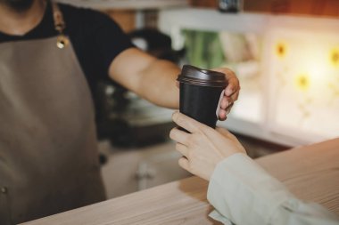 Modern kafe kafe, kafe restoranı, servis zihni, küçük işletme sahibi yiyecek ve içecek konsepti üzerinden dost canlısı bayan müşterilere sıcak kahve servisi yapan genç, yakışıklı adam barista.