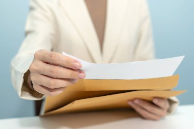 Beyaz takım elbiseli çekici iş kadını evrak zarfından iş raporunu açtı ve ofis ofisindeki toplantı odasında masa başında çalışıyor, dijital çevrimiçi pazarlama ve finansal iş konsepti