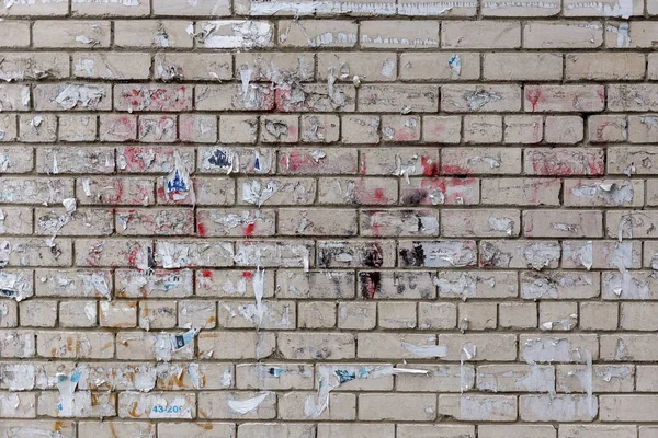 Reklam Kırıntılarıyla Dolu Beyaz Tuğla Duvar — Stok fotoğraf
