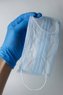 Tıbbi bir eldiven, koruyucu bir maske ve lastik eldiven gösteriyor. Virüsler sırasında kişisel koruma ekipmanlarını sergilemeye uygundur.