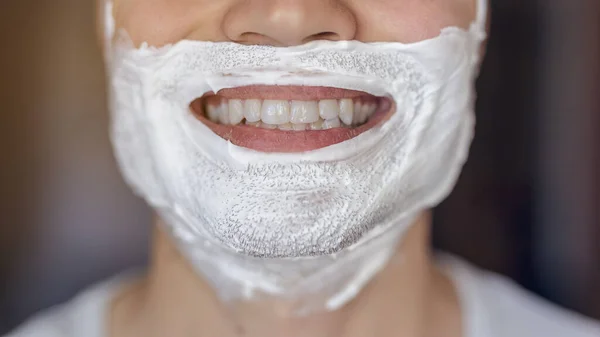 Genç adam traş olur, yüzünde köpükle jilet izi olur.