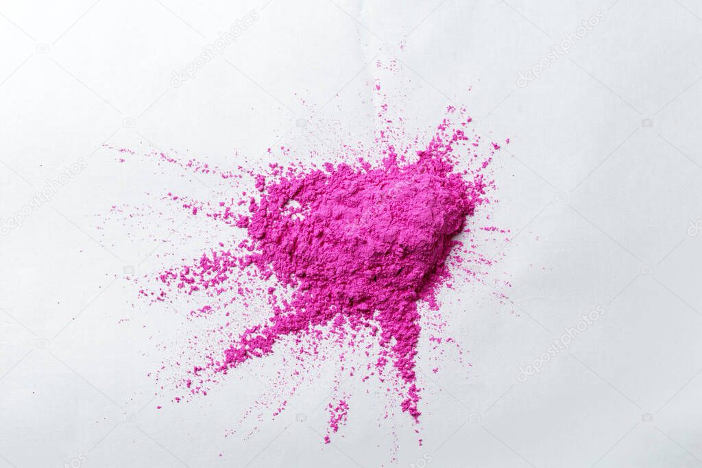 paints for the Holi festival, pink pigmented friable paints lie on a white surface