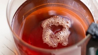 Çay üzerine kalp şeklinde köpük ya da cam bir pasuda dökülen diğer sıvılar.