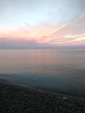 Gün batımından sonra deniz ufukta parlayan bulutlar. Deniz günbatımı. Seascape
