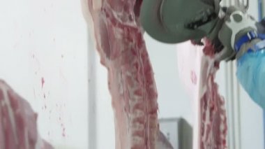 Et işleme fabrikasında et kesen kasap