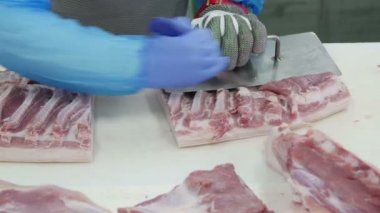 Et işleme fabrikasında et kesen kasap