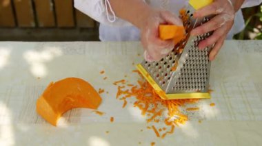 Ev hanımı rende kullanarak balkabağı kesiyor.