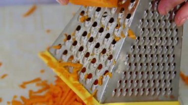 Ev hanımı rende kullanarak balkabağı kesiyor.