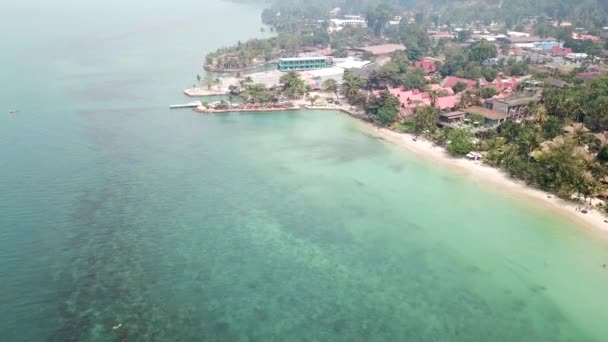 Rök över Thailands hav. Utsikt över klart vatten, gröna kullar på ön med palmer och stranden. Gyllene sand, hotell, folk slappnar av. Dålig sikt på grund av rök. Brand i Kambodja. — Stockvideo