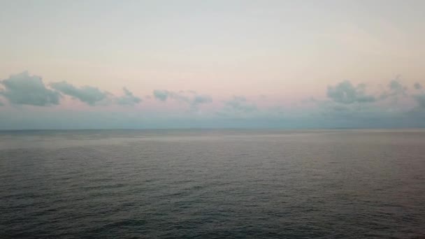 Couleur rose tendre de l'aube sur la mer en Thaïlande. Petites vagues, nuages réfléchis dans l'eau, ciel clair. Tirer depuis un drone. Paix et détente sans personne. — Video